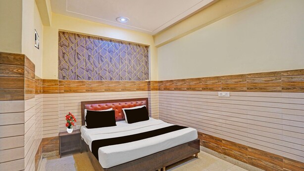 Un dormitorio con cama, mesita de noche y un panel decorativo en la pared.
