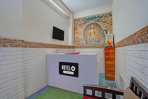 A hotel reception area with a 'HOTELO' sign, a television, and a decorative wall mural. - Hotel O Noida Sector 63 (Noida)