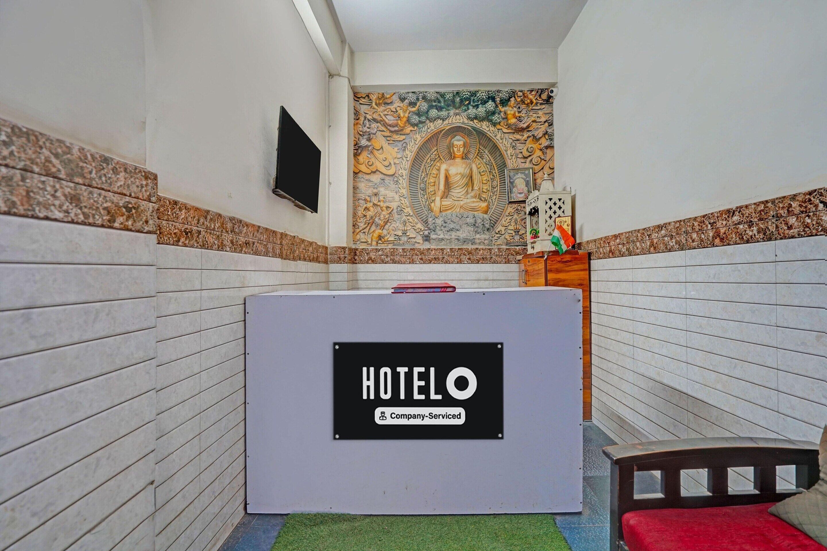 A hotel room with a bed, a sign indicating it's a company-serviced hotel, and a mural on the wall.