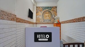 Habitación de hotel con cama, señal que indica que es un hotel de servicio empresarial y un mural en la pared.