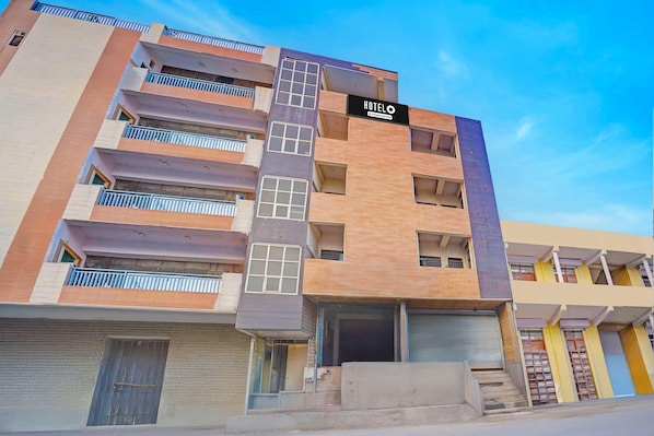 A multi-story hotel with a prominent 'HOTELO' sign, balconies, and a staircase leading to the entrance. - Hotel O Noida Sector 63 (Noida)