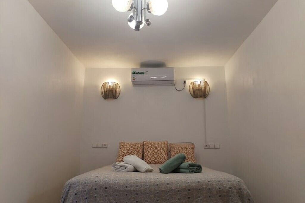Un lit bien fait, avec une couvre-lit à motifs, deux oreillers et des serviettes enroulées.