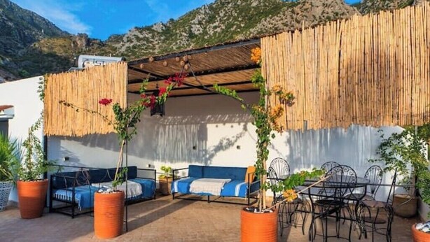 An outdoor seating area with a bed, chairs, and potted plants. - EL SAMA' PRIVATE ROOFTOP HOUSE 80M2 HEART OF OLD MEDINA (Chefchaouen)