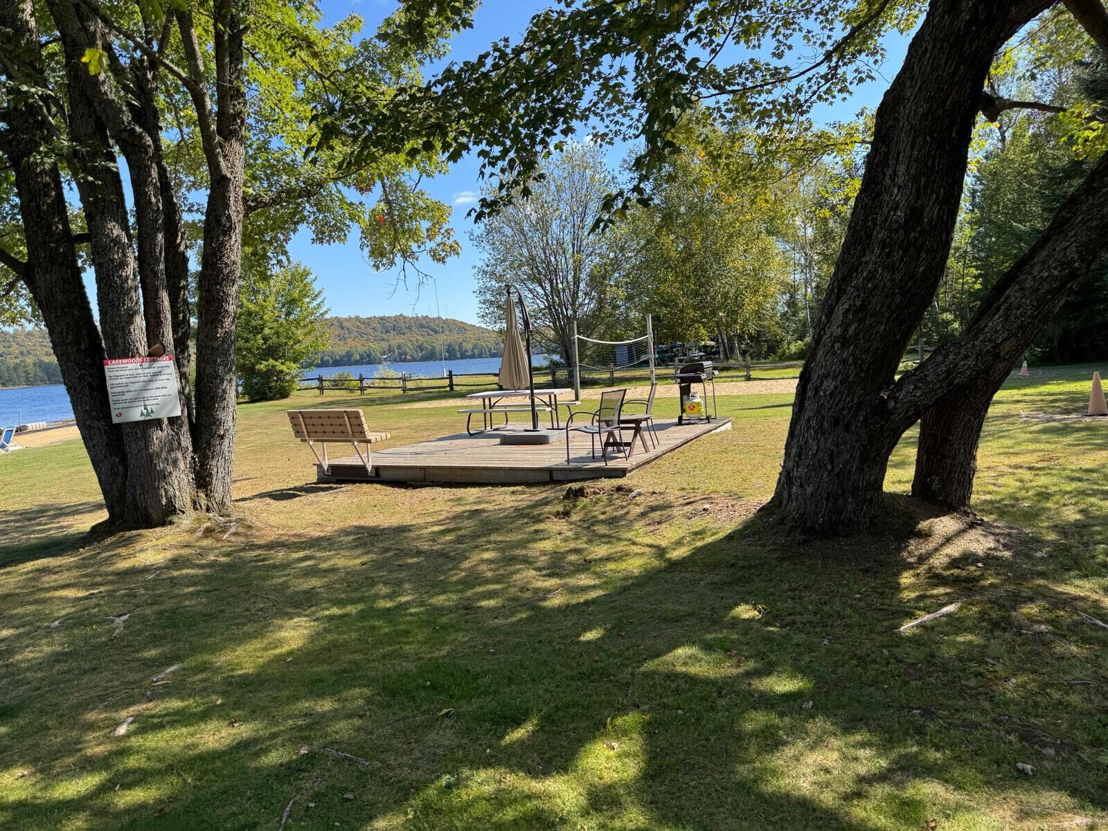 A park with a picnic area, benches, and a lake view.