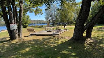 A park with a picnic area, benches, and a lake view.