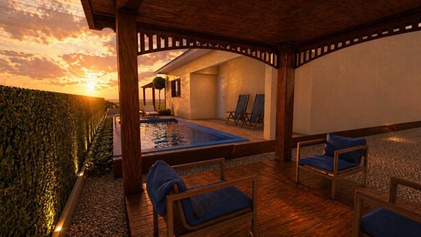 Un espace extérieur abrité comprenant une piscine, des chaises longues et une vue sur le coucher de soleil.