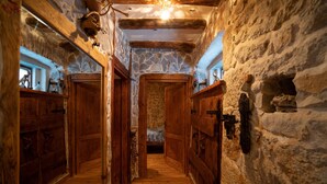 A narrow stone-walled hallway with wooden doors and a rustic interior. - House in a Scenic Siveric Park (Drnis)