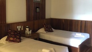 A room with two wooden bunk beds, a small table with a lamp, and a framed picture on the wall. - Nanda Wunn hotel (Nyaungshwe)