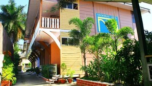 A hotel with a central courtyard, a covered walkway, and a sign indicating the name. - Nanda Wunn hotel (Nyaungshwe)
