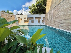 Alberca al aire libre, sombrillas en la alberca y camastros 