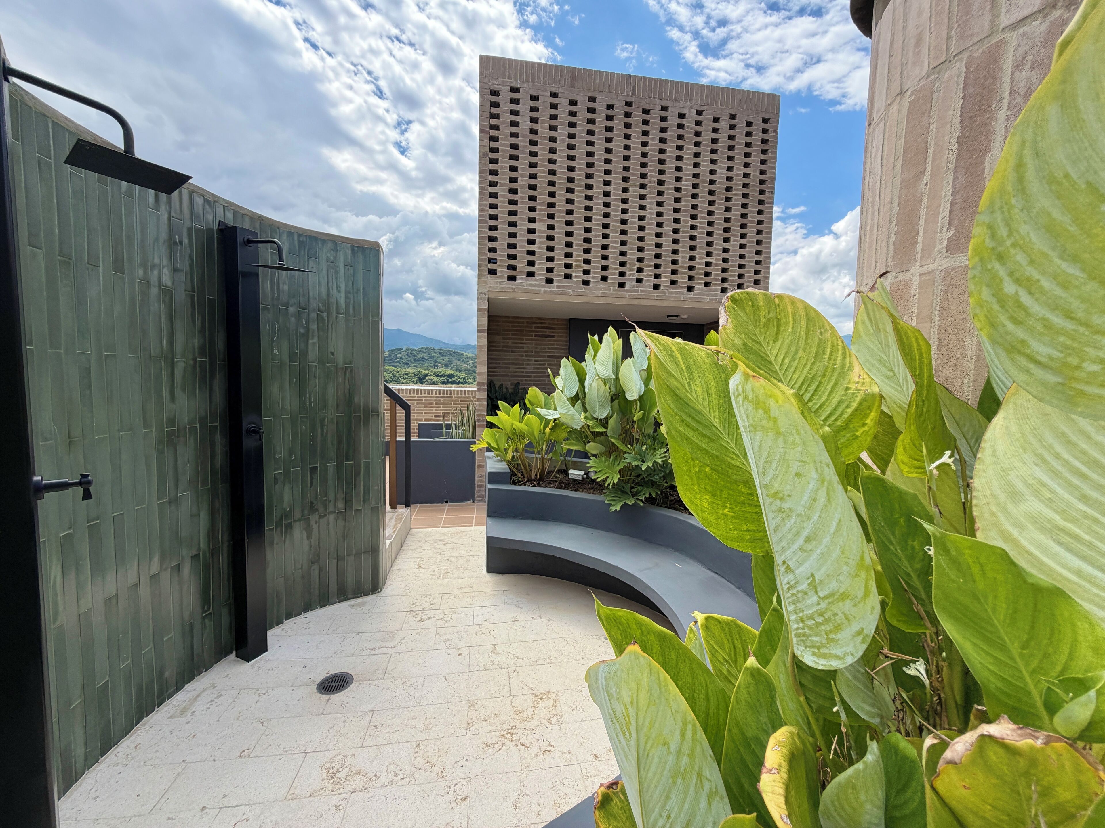 Un edificio moderno con techo plano, amplias ventanas y vistas a una cadena montañosa.