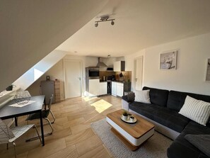 Un apartamento moderno con comedor, sala de estar y cocina.