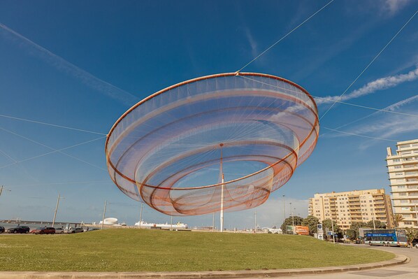A large, circular, transparent structure with a central pole, set against a clear blue sky. - MATOSINHOS OCEAN VIEW by VACATIONY (Matosinhos)