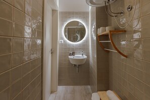 Une salle de bain avec un lavabo, un miroir et une douche.