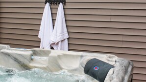 A hot tub with a window above it and two towels hanging on a rack. - Chelton Sanctuary | 7 Person Hot Tub, 2 King Beds, EV Charger, Full Office & A/C (Chelton)