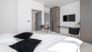 A modern bedroom with a bed, bedside table, and a TV mounted on the wall. - Villa Kalea With Pool (Labin)