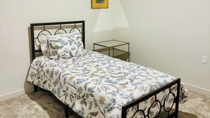 A bedroom with a bed, a bedside table, a wall-mounted lamp, and a framed picture. - Brand new & beautiful home in great neighborhood of N Merced (Merced)