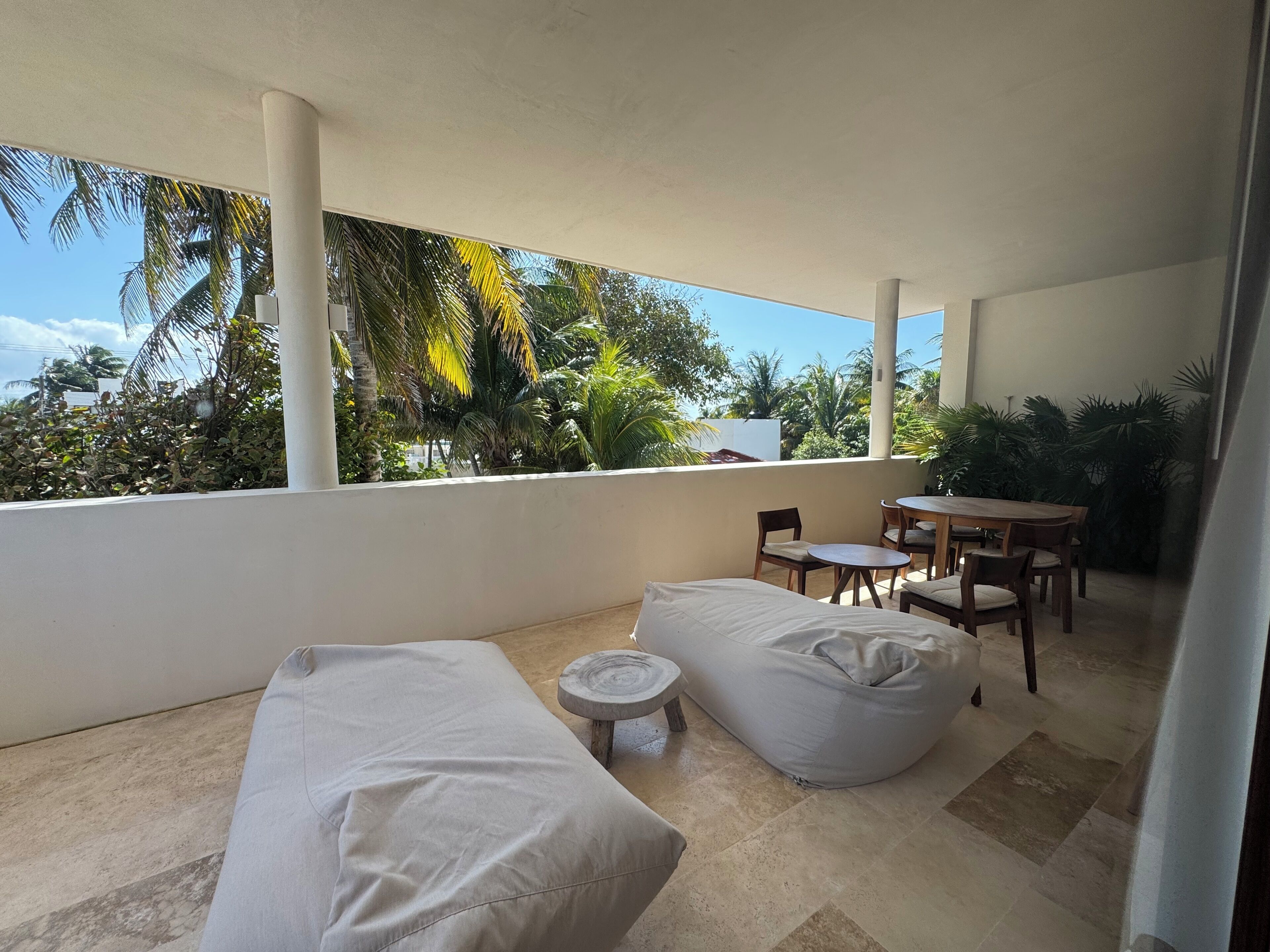 A balcony with a sofa, chairs, and a small table.