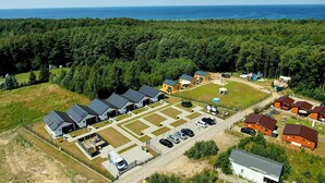 An aerial view of a campground with multiple cabins, a parking area, and a playground. - Comfortable Holiday Homes Close to the Beach (Darlowo)