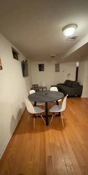 Un comedor con una mesa redonda y sillas, un sofá y una lámpara de techo.