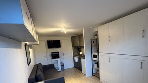 Ett kompakt kök med en matplats, en inbyggd ugn och en mikrovågsugn.