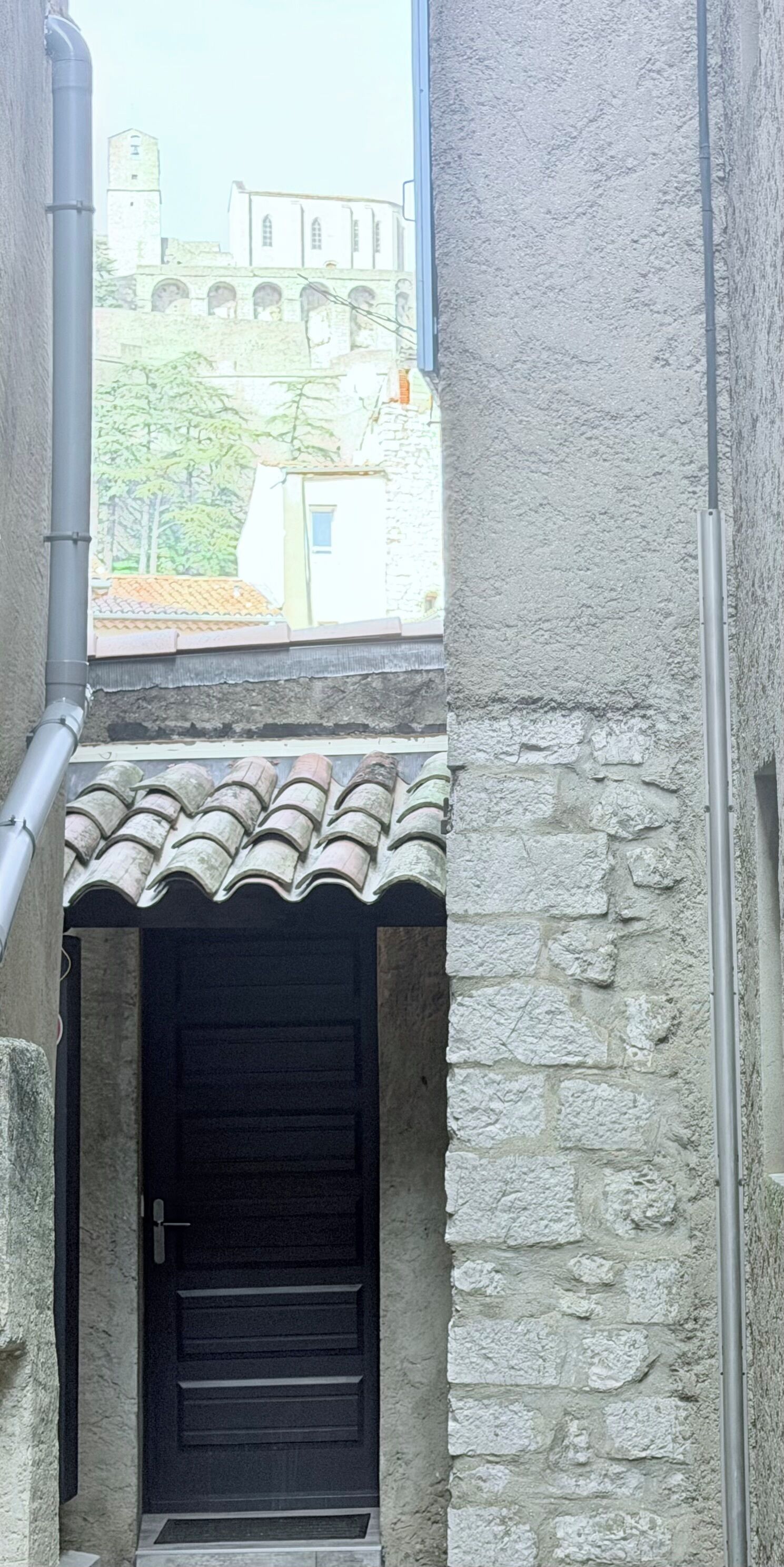 Ein Gebäude aus Stein mit einem Ziegeldach und einem sichtbaren Rohr.