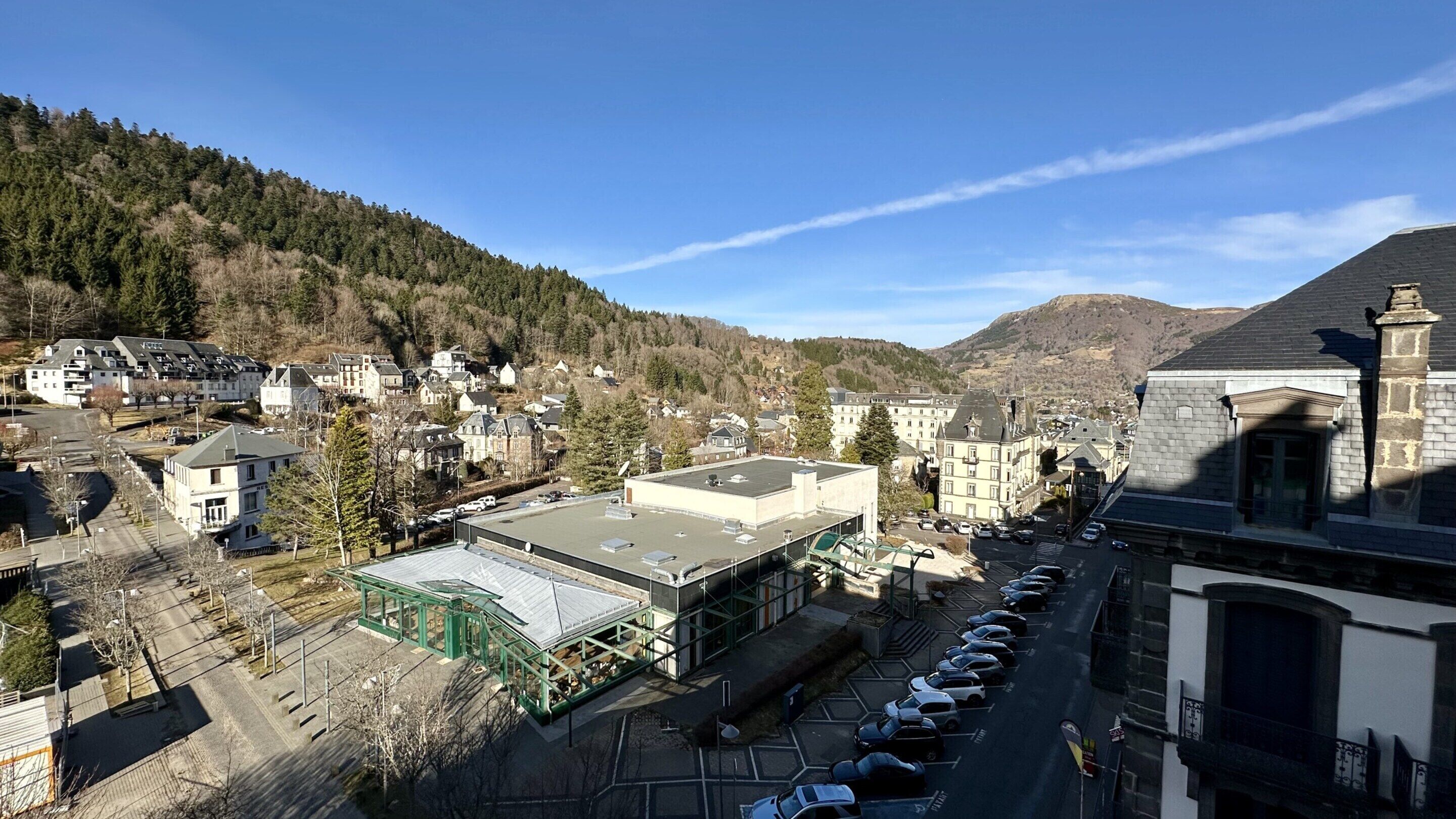 Une ville où se côtoient des immeubles résidentiels et commerciaux, un parking et un bâtiment doté d’un toit végétalisé.