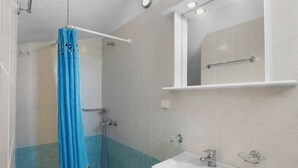 A bathroom with a shower, a sink, and a mirror. - Anthoula's Sea View Apartment (27R5+C6 Piso Livadi)