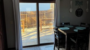 Un coin repas avec une porte-fenêtre coulissante donnant sur un jardin.