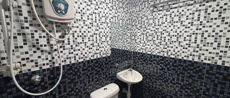 A bathroom with a toilet, a sink, and a shower unit.