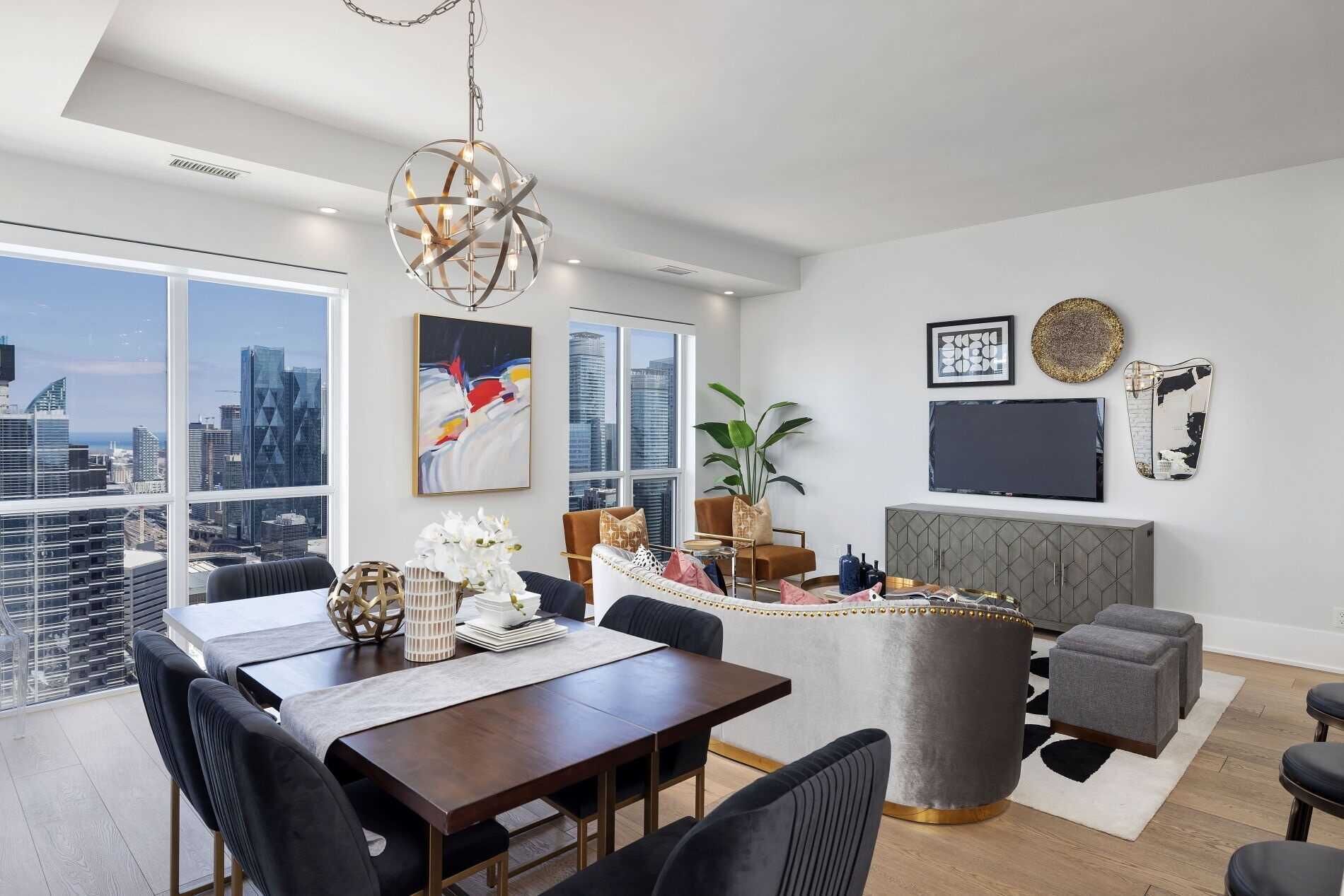 A modern dining area with a city view, a large window, and a unique chandelier.