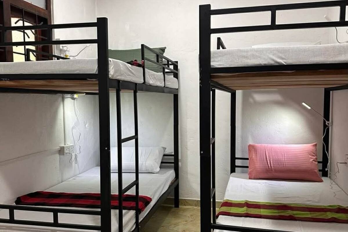 Un dormitorio con literas, una ventana y suelo de baldosas.
