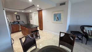 A spacious living area with a kitchen, dining table, and two chairs. - Cape coral/Fort Myers: First floor condo on wide canal next to Jaycee park (Cape Coral)