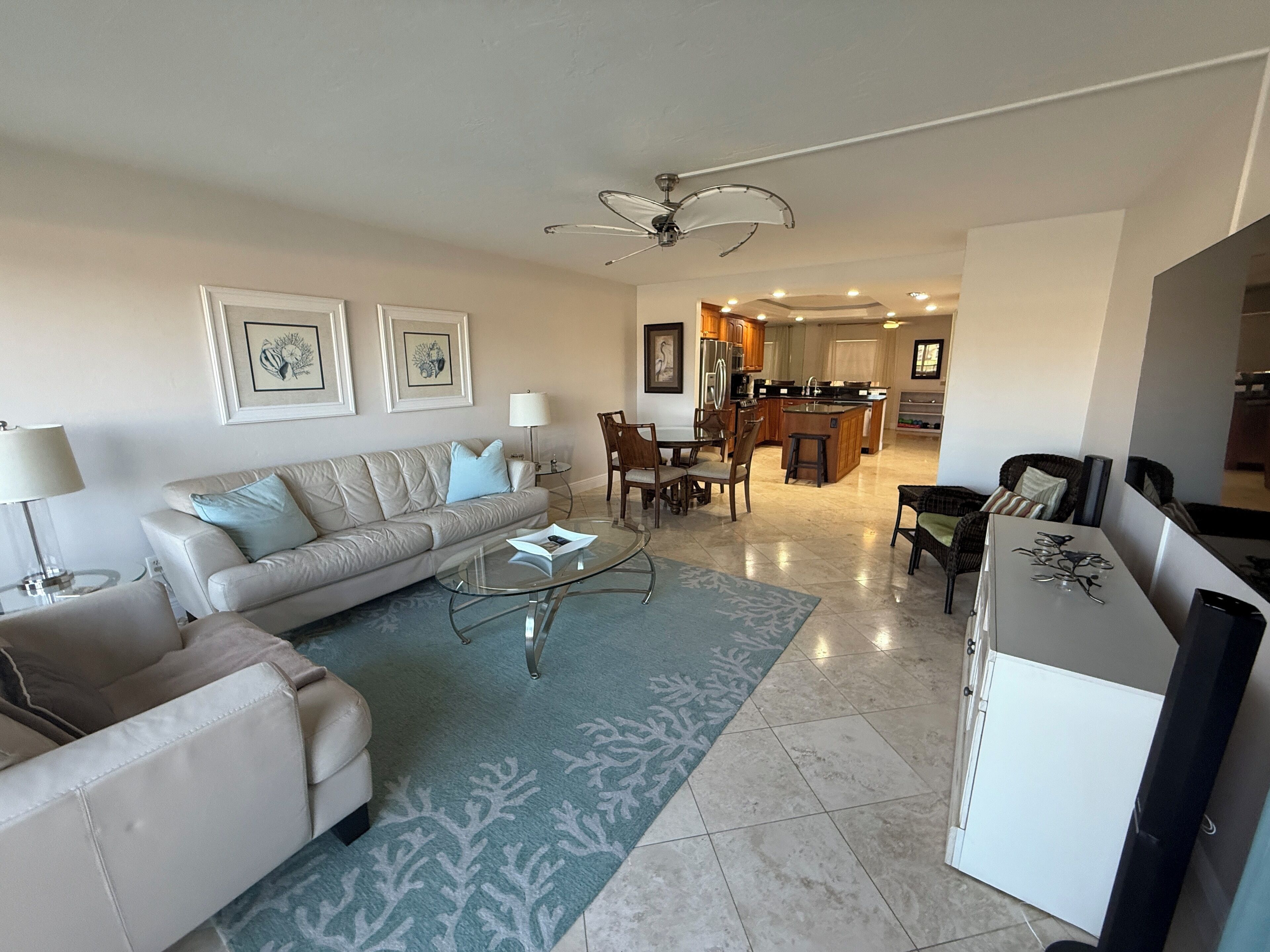 A modern living room with a sofa, coffee table, and dining area.