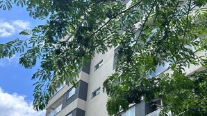 A multi-story building with a sign reading "CAYMAN 385". - AP ENCANTADOR 1 QUARTO PX. DO CAU HANSEN (Joinville)