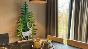 A kitchen with a marble countertop, a decorative tree and deer cutout, a tray with kitchen items, and a window with curtains. - Romantic Getaway at Drenthe Nature Lodge (Dalerveen)
