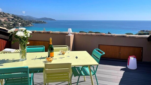 A terrace with a table set for two, a bottle of champagne, and a vase of flowers. - 🌅 ST CLAIR  LAVANDOU  EXCEPTIONAL PENTHOUSE  TOP FLOOR  180° PANORAMIC SEA VIEW (LE LAVANDOU)