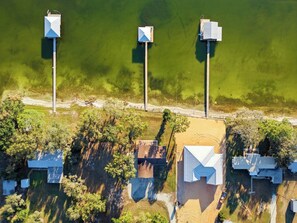 An aerial view of a lakeside property with three buildings, each featuring a prominent rooftop structure.