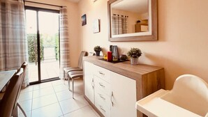 A room with a dining table, chairs, a white cabinet with drawers, a mirror, and a window with curtains. - Sol, Golf & Relax – Luxury house golf & sea (San Jorge)