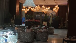 Eine Lobby mit Sitzgelegenheiten, einer Glastheke und einem Ziertelegramm.