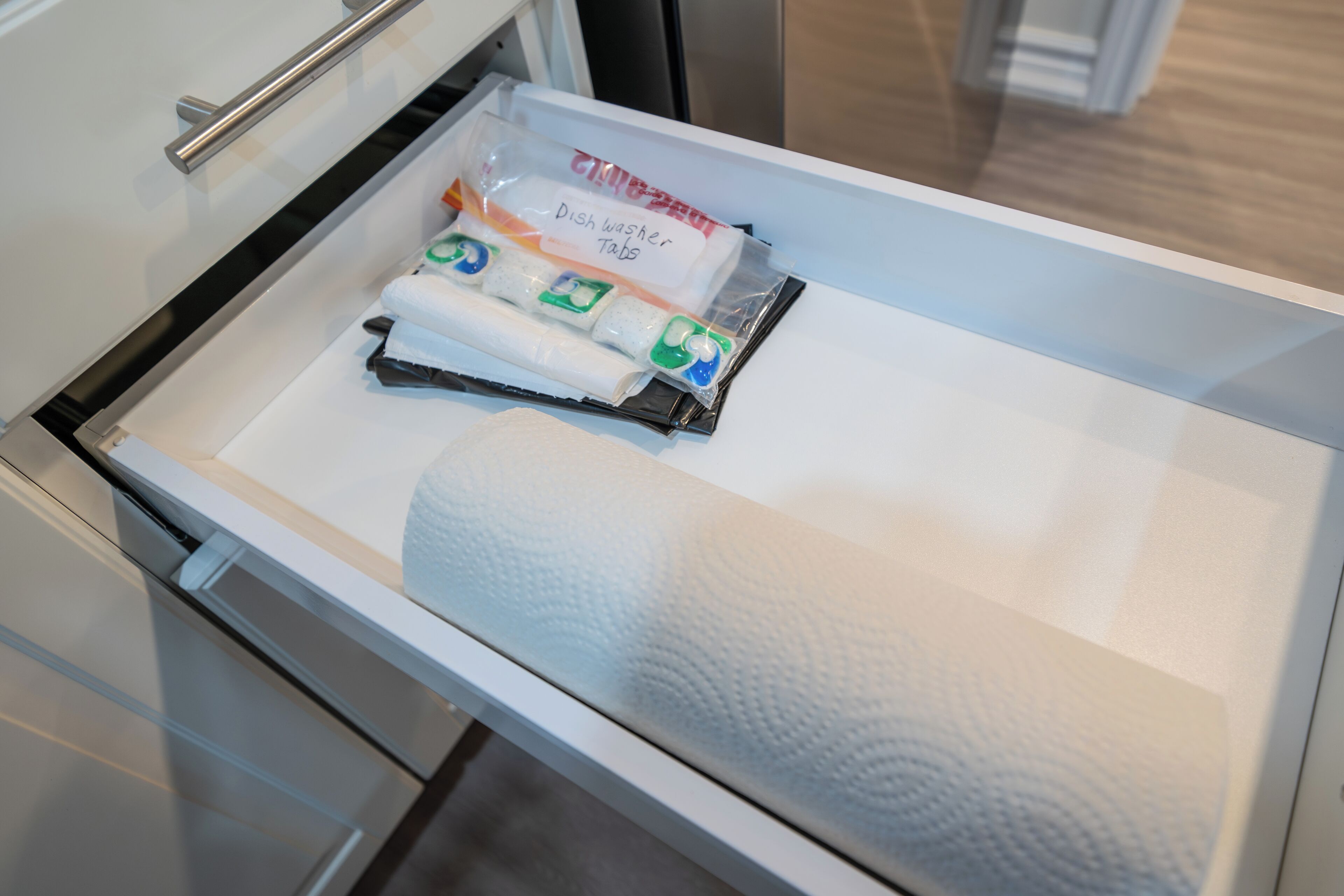 A drawer with a dish washer tab and a white towel.