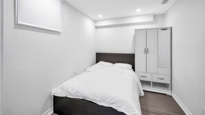 Een slaapkamer met een bed, een kledingkast en een dakraam.
