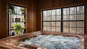 Ein Whirlpool mit Holzvertäfelung, ein Fenster mit Blick auf Bäume und ein Regal mit Pflanzen und Dekoration.