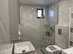A modern bathroom with a glass-enclosed shower, a white sink, and a toilet. - 2-br Countryside Apartment in Mouzaki (Zakynthos)