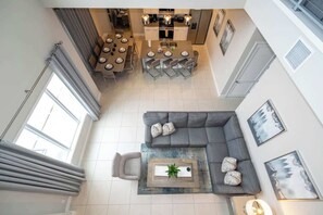 Un interior moderno con comedor, sofá y una mesa de centro con una planta.