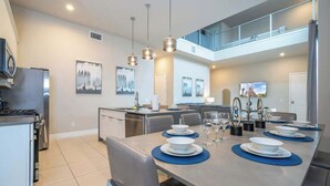 Une cuisine moderne avec un coin repas, un plafond haut et une mezzanine.