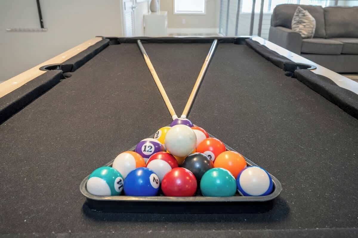 A pool table with a triangular rack of billiard balls.