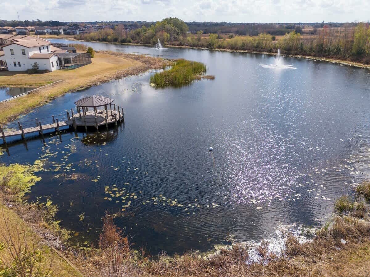 A river with a gazebo, a house, and a fountain.