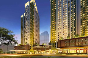 A high-rise hotel with multiple floors, a covered entrance, and a modern architectural design.