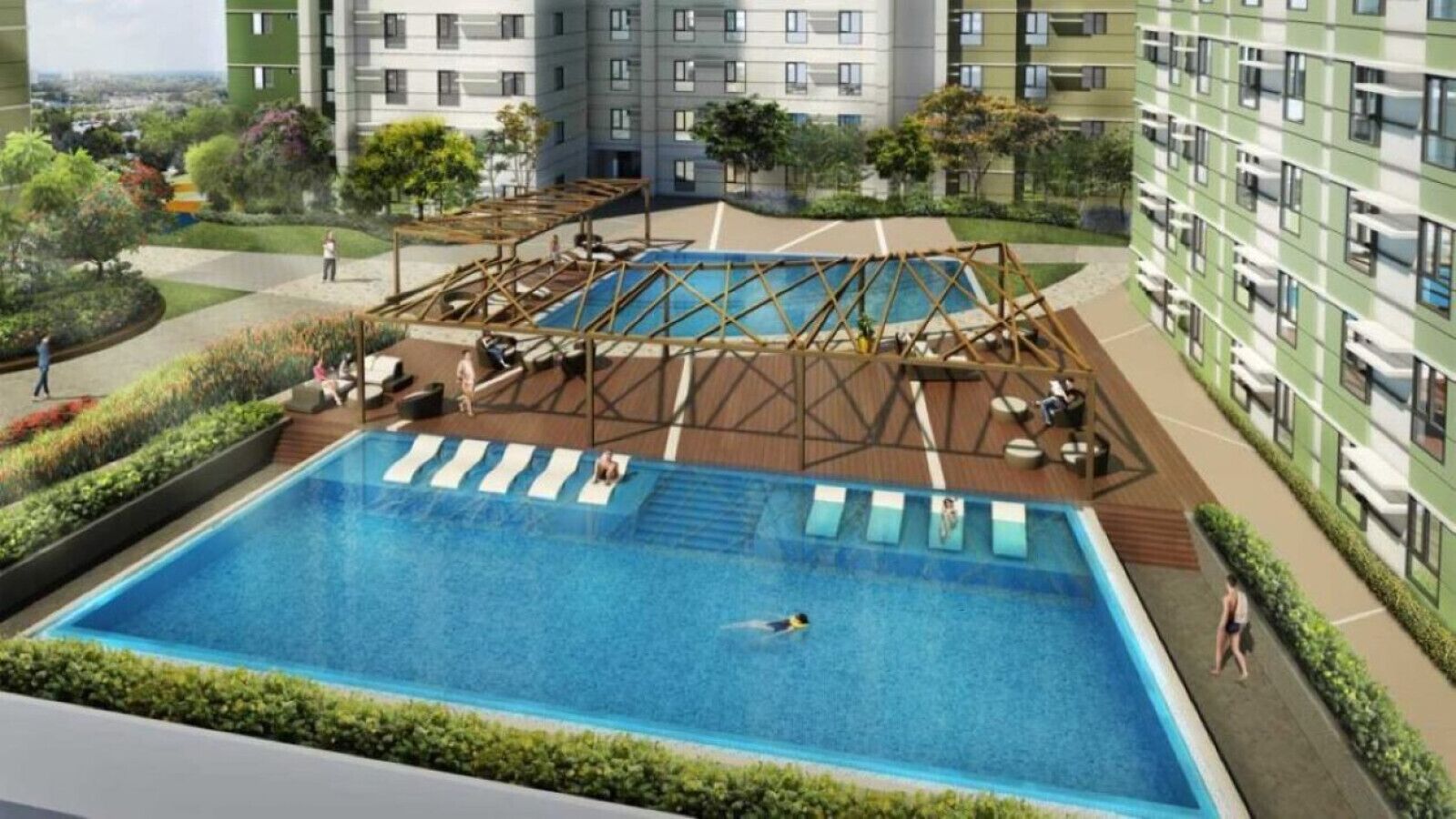 Zwembad met ligbedden en een houten terras, omringd door groen en een meerhoog gebouw.